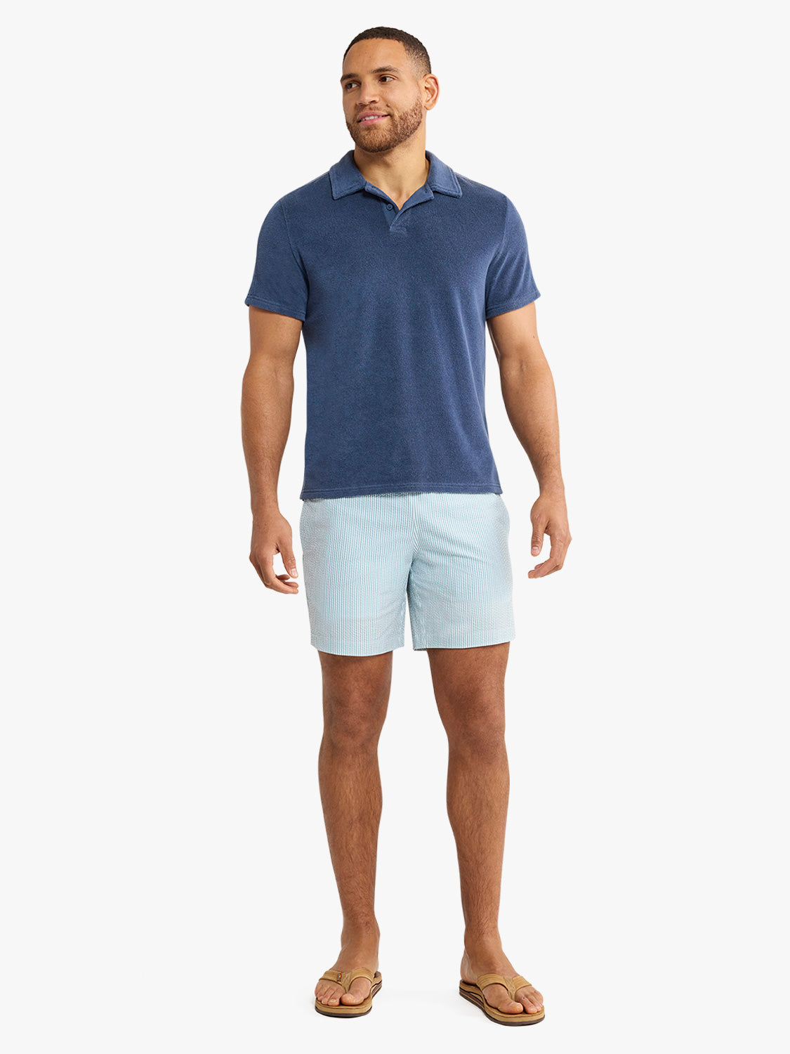 Man wearing a navy terry polo shirt with short sleeves and a collar.