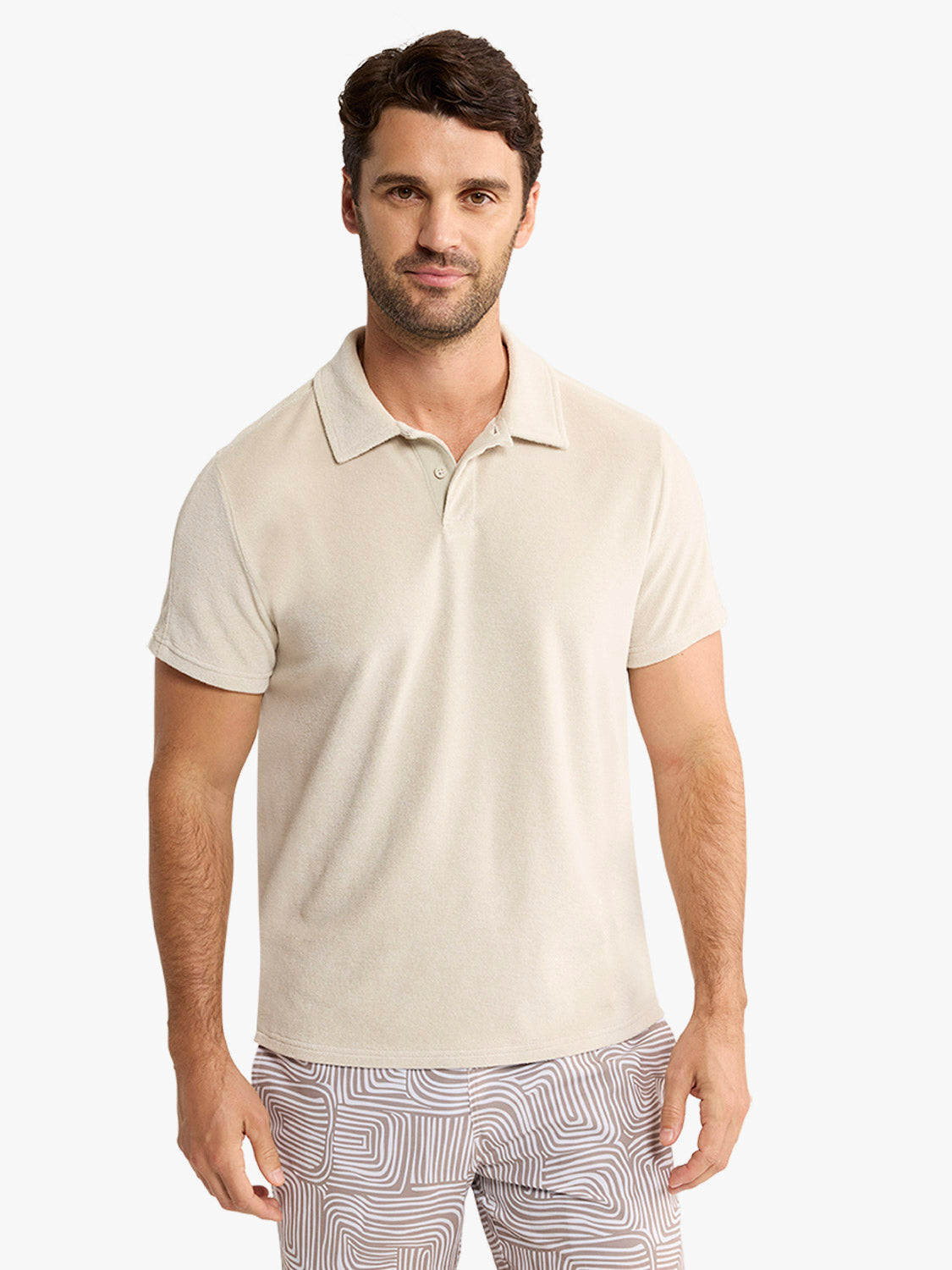 Man wearing a sand-colored short-sleeve polo shirt with a collar and button placket.