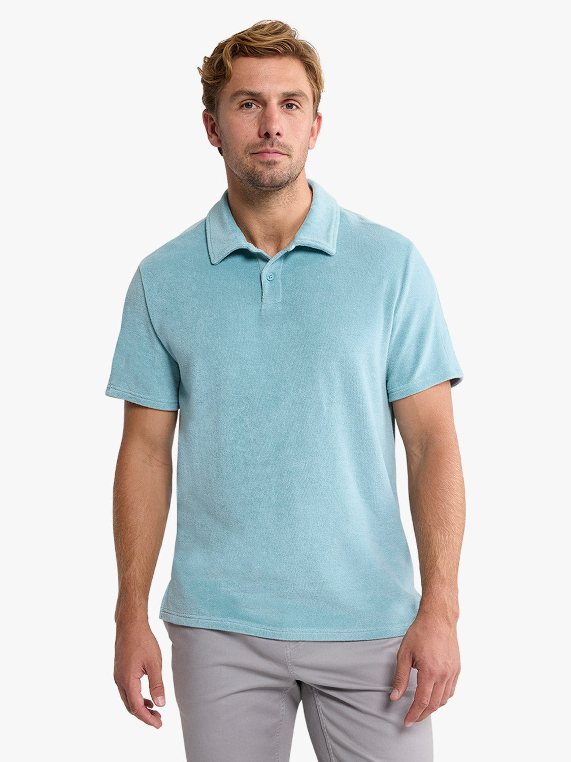 Man wearing a bay blue terry polo shirt with short sleeves and gray pants.