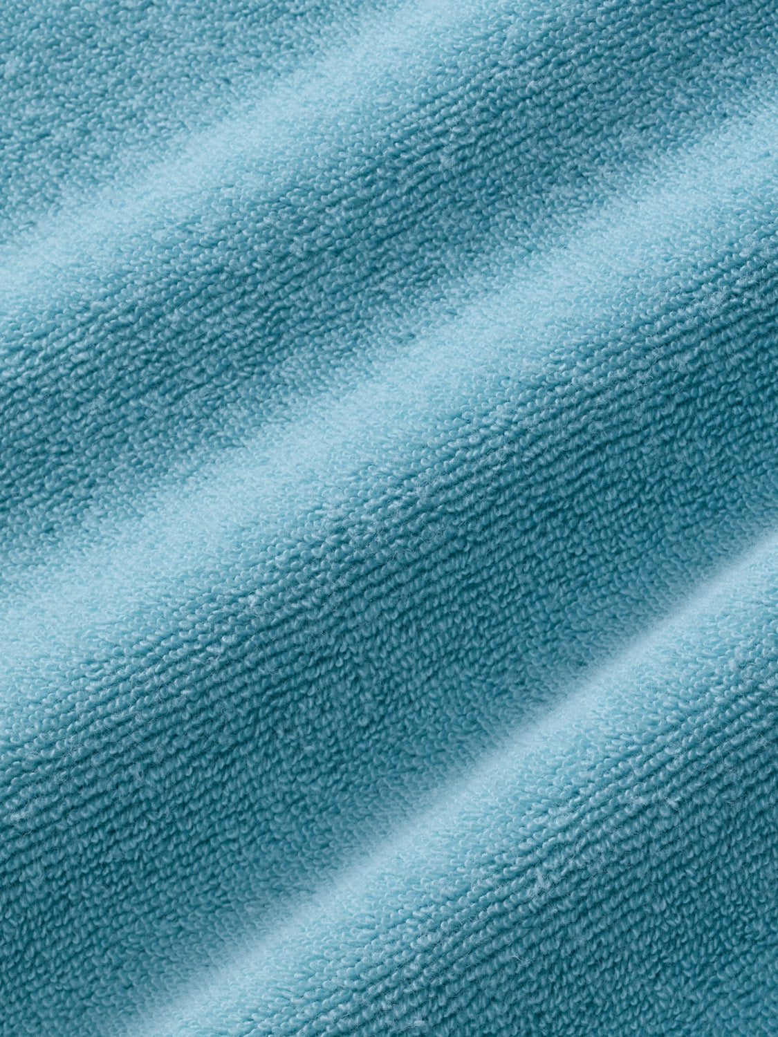 Close-up of bay blue terry fabric showing textured woven surface with diagonal fold lines.