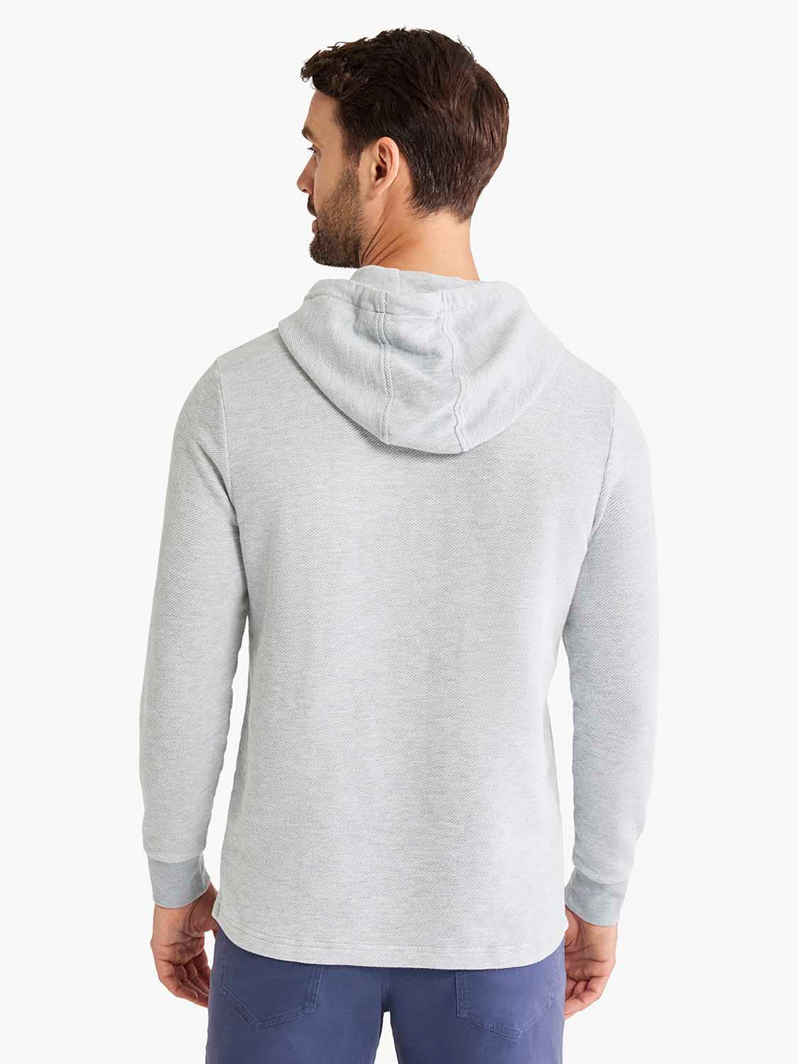 Man wearing a heather grey hoodie with long sleeves and a drawstring hood, shown from the back.