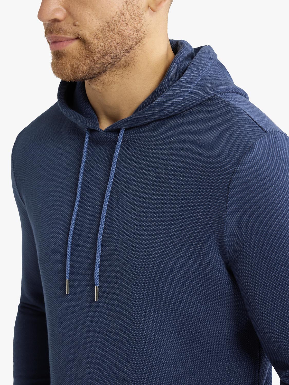 Man wearing a navy blue textured hoodie with drawstring closeup showing fabric detail and fit.