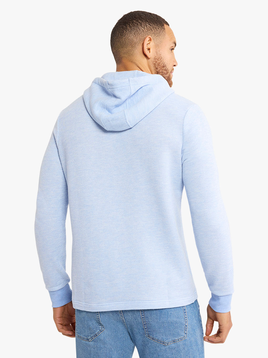 Man wearing a light blue hoodie with a drawstring hood, shown from the back and side profile.
