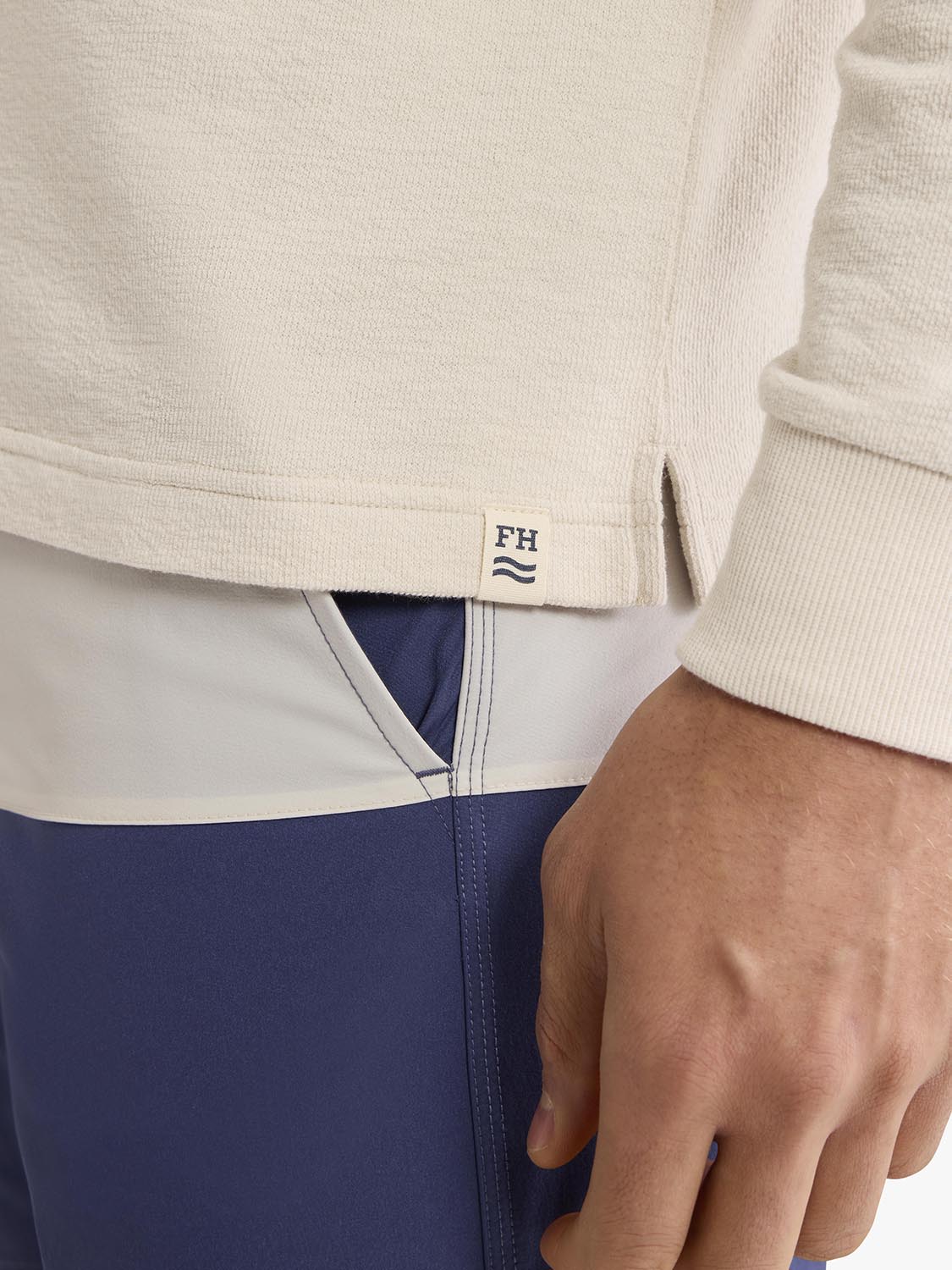 Cream terry hoodie with horizontal stripe detail in navy and white, worn with matching navy shorts.