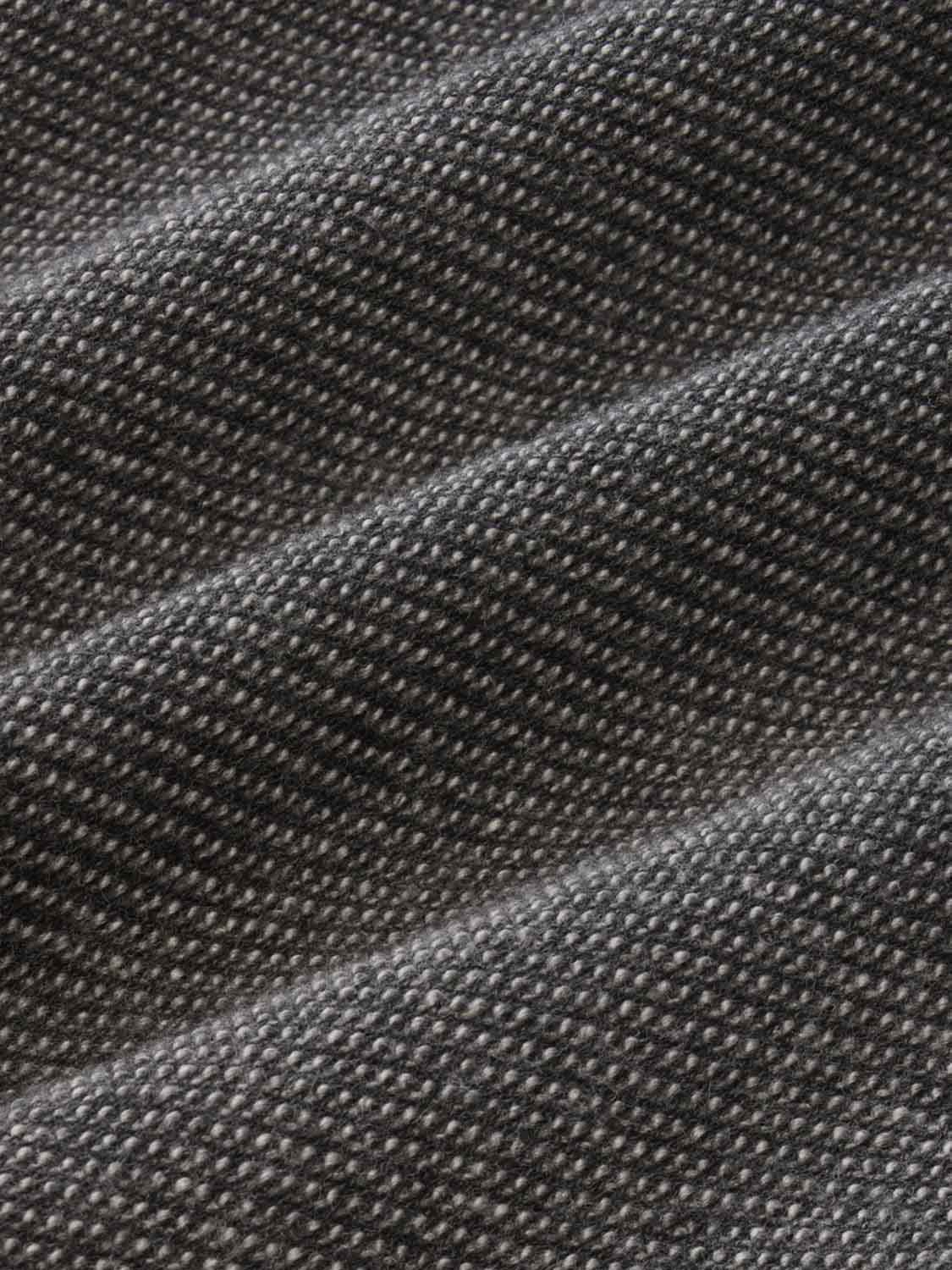 Close-up of charcoal gray sweatpant fabric showing textured knit weave pattern.