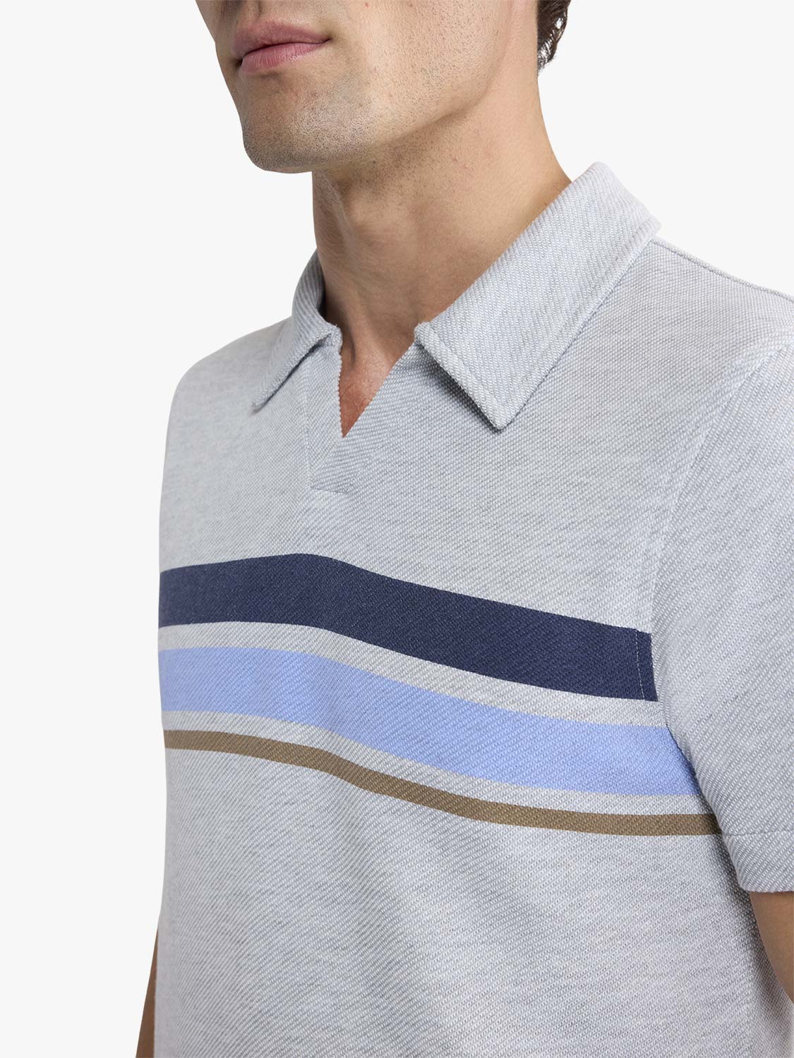 Man wearing a heather grey polo shirt with navy, light blue, and tan horizontal stripes across the chest.