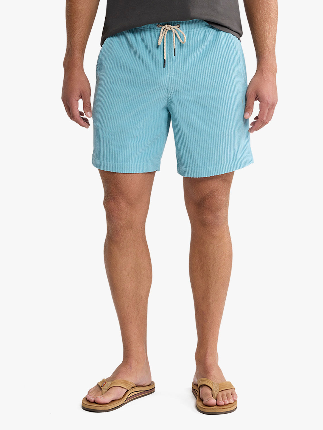 Man wearing bay blue corduroy shorts with drawstring waistband and tan sandals.
